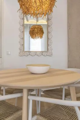 a dining room table with a mirror and a chandelier at ApartUP Ca La Leni Beach III in Valencia