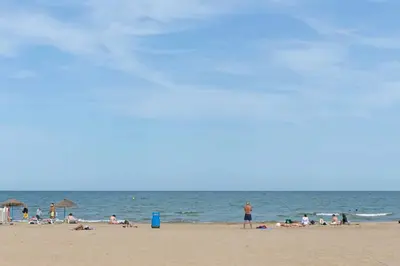 a group of people on a beach with the ocean at ApartUP Ca La Leni Beach III in Valencia
