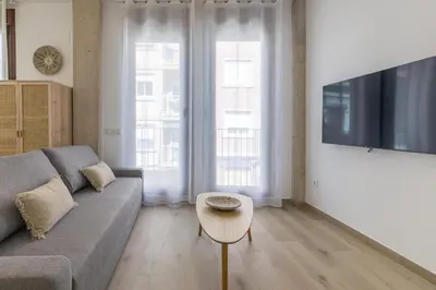 a living room with a couch and a table at ApartUP Ca La Leni Beach III in Valencia