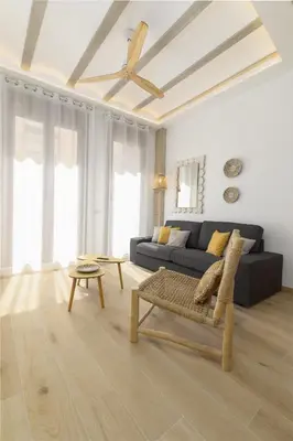 a living room with a couch and a ceiling fan at ApartUP Ca La Leni Beach II in Valencia