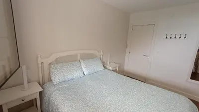 a white bedroom with a bed and a window at ROYAL BEACH - Appartment with sea view & terrace in Faro de Cullera