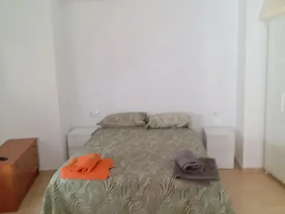 a bedroom with a bed with a pink and yellow comforter at Apartamentos Torresmar in Altura