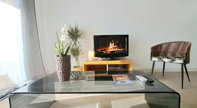 a living room with a tv and a table with a fireplace at Piso nuevo y luminoso ESTANCIAS DE TEMPORADA Mín 12 noches in Valencia
