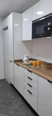 a kitchen with white cabinets and a wooden counter top at Piso nuevo y luminoso ESTANCIAS DE TEMPORADA Mín 12 noches in Valencia