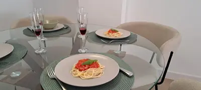 a table with two plates of pasta and glasses of wine at Piso nuevo y luminoso ESTANCIAS DE TEMPORADA Mín 12 noches in Valencia