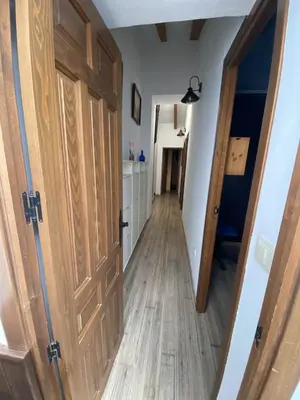a hallway with a wooden door leading to a kitchen at Casa Rural El Molino in Macastre