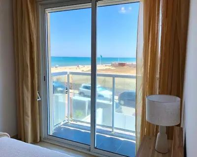 a bedroom with a window with a view of the beach at Vacaciones con el Mediterráneo a menos de 50 metros in Cullera