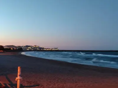 a beach with a sign in the sand and the ocean at Vacaciones con el Mediterráneo a menos de 50 metros in Cullera