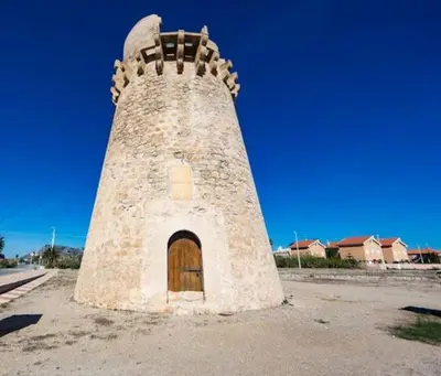 a tall brick tower with a door in the middle at Vacaciones con el Mediterráneo a menos de 50 metros in Cullera