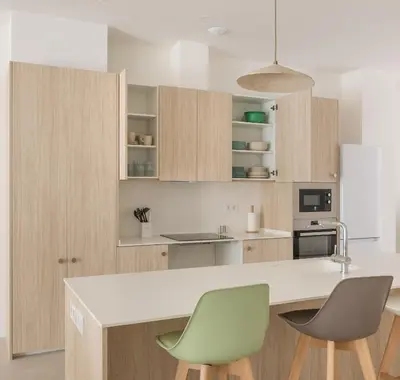 a kitchen with a white counter and two green chairs at Casa Ramona Ruzafa Valencia Centro in Valencia