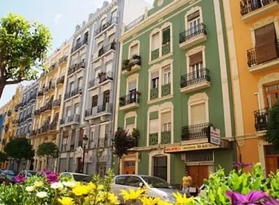a green building on a city street with flowers at Casa Ramona Ruzafa Valencia Centro in Valencia