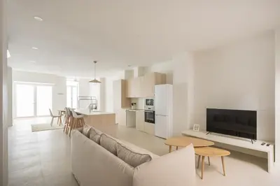 a living room and kitchen with a couch and a table at Casa Ramona Ruzafa Valencia Centro in Valencia