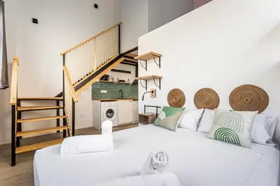 a living room with a white couch and a staircase at Marie Curie Flats, Lovely Loft in Valencia