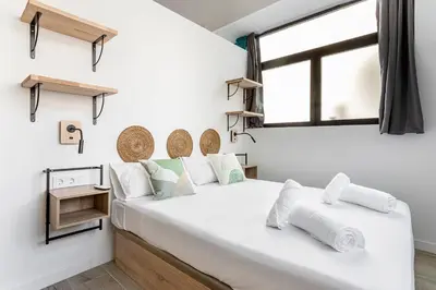a white bedroom with a large white bed and a window at Marie Curie Flats, Lovely Loft in Valencia