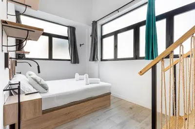 a bedroom with white walls and windows and a bed at Marie Curie Flats, Lovely Loft in Valencia