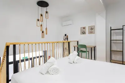 a bedroom with a bed with towels on it at Marie Curie Flats, Lovely Duplex 2 in Valencia