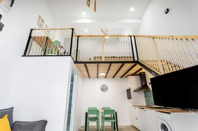 a living room with a staircase and green stools at Marie Curie Flats, Lovely Duplex 3 in Valencia