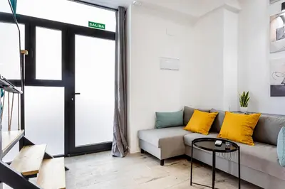 a living room with a couch with yellow pillows at Marie Curie Flats, Lovely Duplex 3 in Valencia