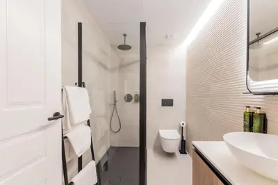 a white bathroom with a sink and a toilet at Guastavino by Alma Suites in Valencia