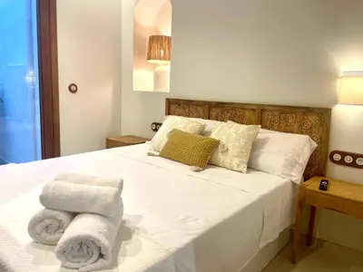 a bedroom with a white bed with towels on it at Pepitas House in Valencia