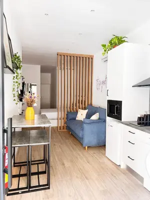 a living room with a blue couch in a kitchen at Apartamento junto a Ruzafa cerca del centro in Valencia