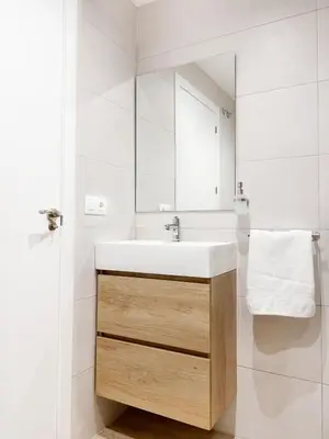 a white bathroom with a sink and a mirror at Apartamento junto a Ruzafa cerca del centro in Valencia