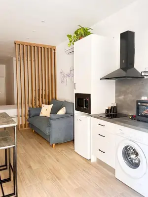 a living room with a couch and a kitchen at Apartamento junto a Ruzafa cerca del centro in Valencia