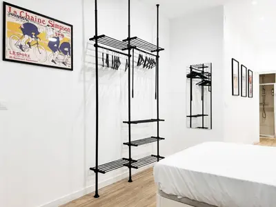 a room with a bed and some shelves in a room at Apartamento junto a Ruzafa cerca del centro in Valencia