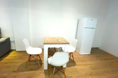 a table with four chairs and a refrigerator in a room at Apartamento Cienciasmar in Valencia