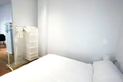 a white bedroom with a bed and a closet at Apartamento Cienciasmar in Valencia