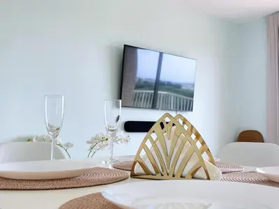 a dining room table with a tv on the wall at Marinao Apartment in Playa Pobla de Farnals