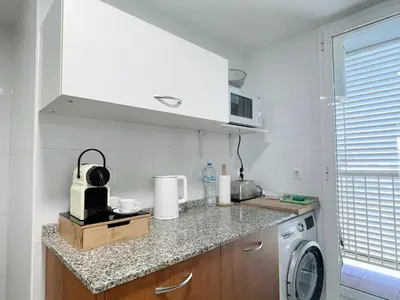 a kitchen with a sink and a washing machine at Marinao Apartment in Playa Pobla de Farnals