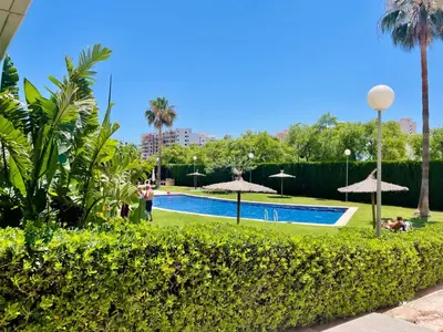 a swimming pool with umbrellas in a park at Marinao Apartment in Playa Pobla de Farnals