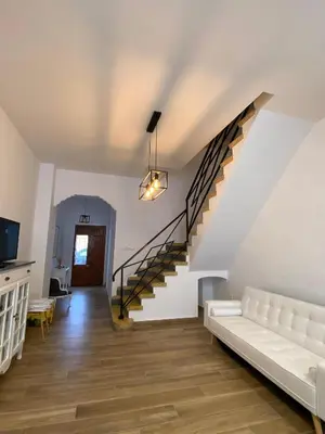 a living room with a white couch and stairs at Casa La Culle in Favareta