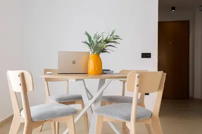 a wooden table with a laptop and two chairs at Apartamento Palermo Living Suites en Burriana in Burriana