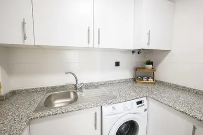 a kitchen with a sink and a washing machine at Apartamento Palermo Living Suites en Burriana in Burriana