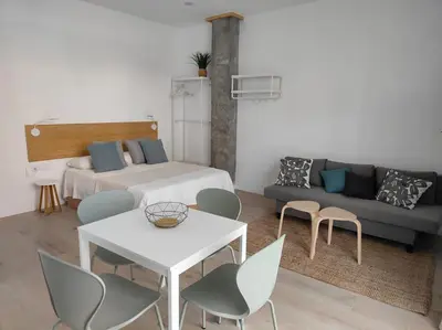 a living room with a bed and a table and chairs at Loft nuevo cerca de Ruzafa in Valencia