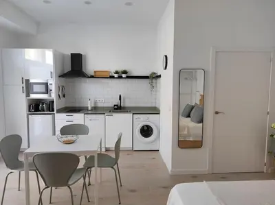 a white kitchen with a table and chairs at Loft nuevo cerca de Ruzafa in Valencia