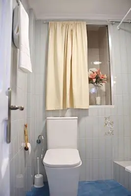 a bathroom with a white toilet and a window at Casa Rural Buñol Ca Maruja-Experiencia Unica in Buñol