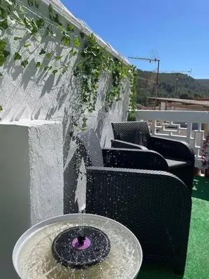 a table with a purple bowl on top of a fountain at Casa Rural Buñol Ca Maruja-Experiencia Unica in Buñol