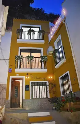 a yellow building with two balconies and a door at Casa Rural Buñol Ca Maruja-Experiencia Unica in Buñol