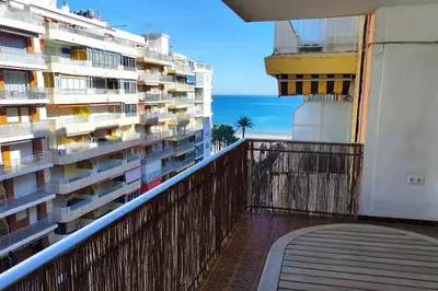 a balcony with a view of a building and the ocean at Apartamento en Cullera in Cullera