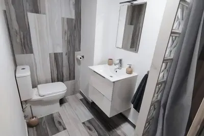 a white bathroom with a toilet and a sink at Apartamento en Cullera in Cullera