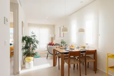 a dining room and living room with a table and chairs at Terrasses - Beach apartment with swimming pool in Puzol