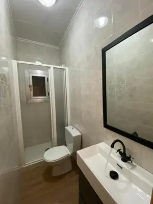 a bathroom with a toilet and a sink and a mirror at BajoPlaya in Burriana
