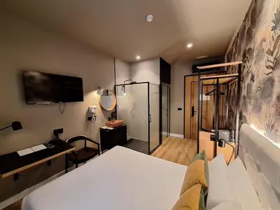 a bedroom with a bed and a tv and a bathroom at Saman Hotel Boutique in Valencia
