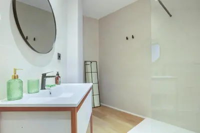 a white bathroom with a sink and a mirror at Mestalla Flats by Nomad Host in Valencia
