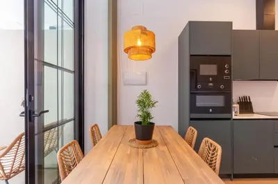 a dining room with a wooden table and a potted plant at Mestalla Flats by Nomad Host in Valencia