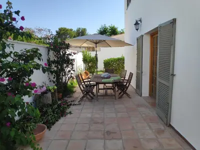 a patio with a table and chairs and an umbrella at La Casa del Sol in La Eliana