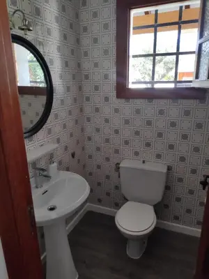 a bathroom with a toilet and a sink and a window at La Casa del Sol in La Eliana
